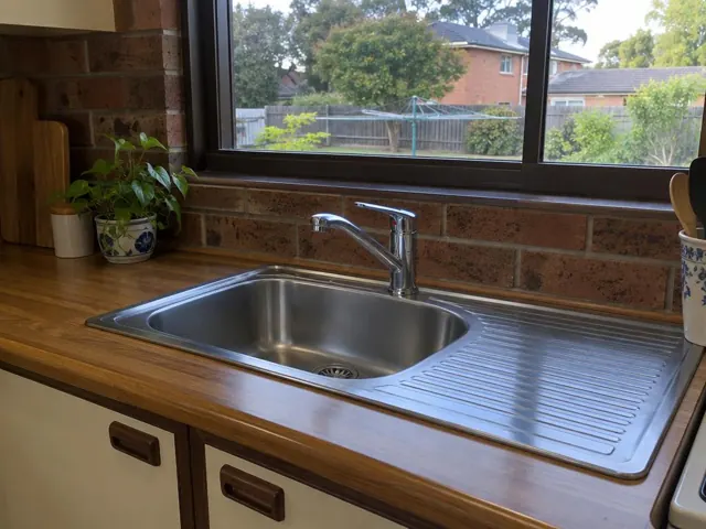 Kitchen sink with new chrome tap, timber bench and brick splashback in Carlingford